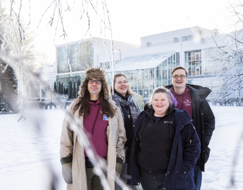 Neljä ihmistä katsoo kameraan talvisessa Sorsapuistossa.