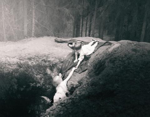 Lapsi ojentaa auttavan käden toiselle.