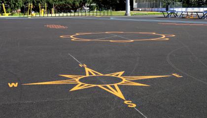 Kompassi, noidanpata ja hyppyruudukko maalattuna pelikentälle.