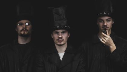 Kolme opiskelijaa mustissa hatuissa.