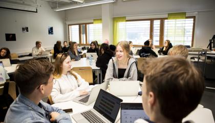Opiskelijoita luokassa kannettavien tietokoneiden kanssa.