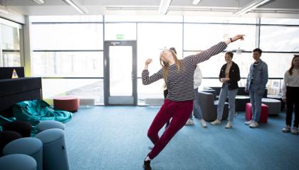 Opiskelija tanssii, taustalla muita.