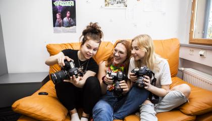 Opiskelijoita kameran kanssa sohvalla.