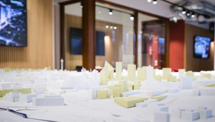 Siluetissa sijaitseva pienoismalli Tampereen keskustasta. Kuvassa näkyy vaaleankeltaisia ja valkoisia 3D-printattuja rakennuksia.