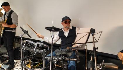 Aurinkolasit kasvoillaan oleva muusikko soittaa rumpuja tamperelaisten illassa.