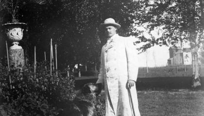 Mies ja koira ulkona puistossa.