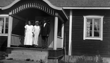 Haiharan Väentuvan kuistilla seisoo kolme ihmistä.