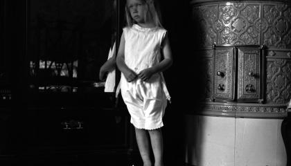 Pieni tyttö seisoo paljain jaloin Haiharan kakluunin edessä.