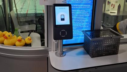 Uimahallin QR-koodin lukijalaite ja korissa rannekkeita.