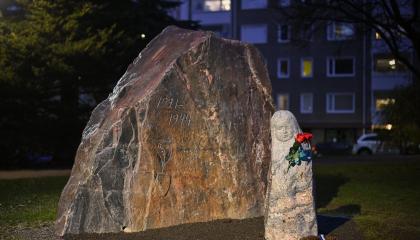 Läpi harmaan kiven -Lotta Svärd -muistomerkki pimeän aikaan valaistuna