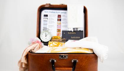 Avonaisen matkalaukun sisällä on lakanoita, papiljotit ja herätyskello.