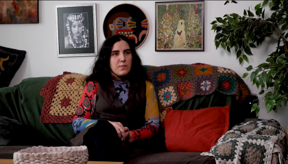 Nainen istuu sohvalla 