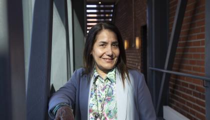 Henkilö hymyilee pilareiden välissä.