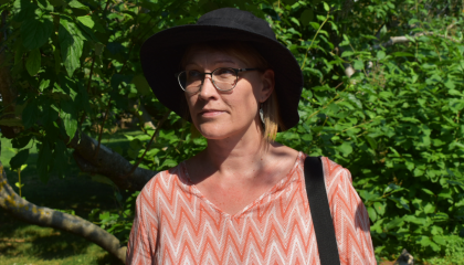 Henkilö pensaan edessä. Laura Tikkanen.