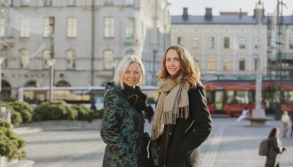 Maiju Viiki ja Anna-Kaisa Heinämäki seisovat Tampereen Keskustorilla ja taustalla kulkee ratikka ja bussi.
