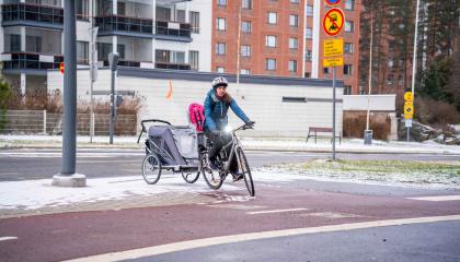 Talvipyöräilijä peräkärröyneen kääntyy pyörätielle.