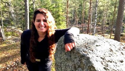 Catherine Ghersi nojaa isoon kiveen metsän keskellä 