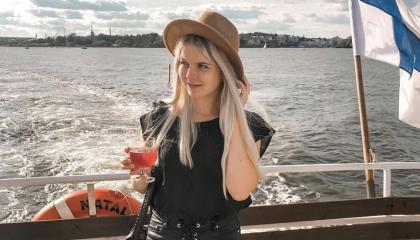 Victoria Laaksonen  veneen perässä Suomen lippu vieressään