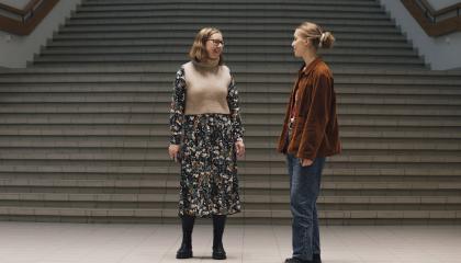 Opettaja Maarit Luhtala ja opiskelija Aliisa Turunen keskustelevat koulun portaiden luona.