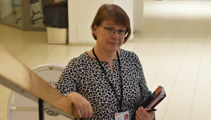 Henkilö seisoo portaikossa kansio kädessään.