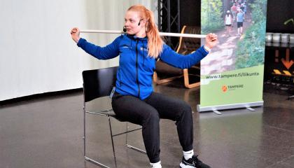 Liikunnanohjaaja ohjaa tuolijumppaa.