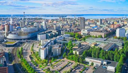 Ilmakuvanäkymässä Tampereen keskusta kesäaikaan, aurinko paistaa, taivas on sininen, puut vihreitä ja taustalla korkeita rakennuksia..