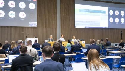 kaupunginvaltuusto kokouksessaan, ihmisiä istumassa pöytiensä ääressä ja puheenjohtaja edessä johtamassa puhetta isossa Tampere-talon salissa.