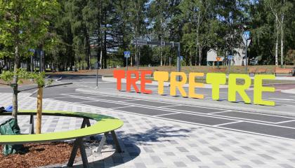 Kalevan liikennepuiston ajoradat ja puistoon sijoitettu Tre tre tre - tekstikyltti.