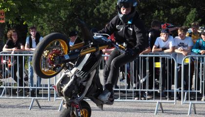 Nuori henkilö keulii mopolla mopomiitissä.