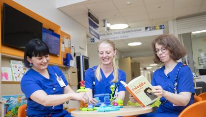 Kolme varhaiskasvatuksen työntekijää istuu pyöreän pöydän ympärillä