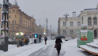 Jalankulkija Keskustorilla lumipyryllä.