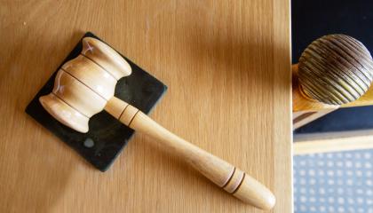 Puinen nuija valtuuston puheenjohtajan pöydällä makaamassa.