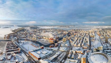 Dronella otettu maisemakuva, jossa etualalla luminen Nokia Arena ja Ratina, keskellä Tammerkoskea ympäröivät tiilitalot ja taustalla Näsijärvi.