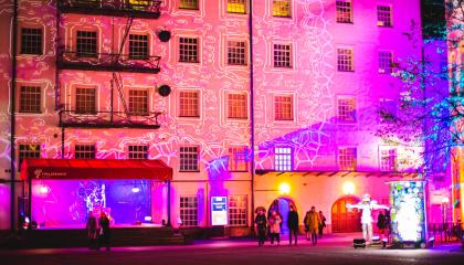 Valotaidetta hämärällä kerrostalojen sisäpihalla. 