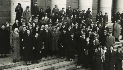 Suuri joukko ihmisiä seisoo eduskuntatalon portailla.