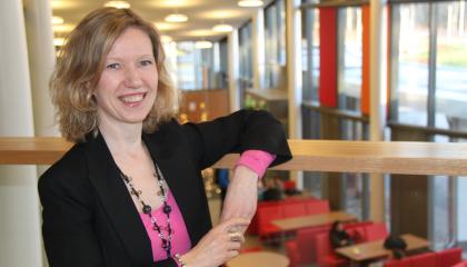 Henkilö nojaa kaiteeseen. Taustalla näkyy kahvila.