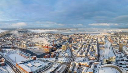 Ilmakuva talvisesta Tampereen kaupungin keskustasta ja taustalla sininen taivas.