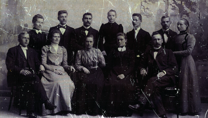 12 henkilöä luokkakuvaa muistuttavassa ryhmäkuvassa.