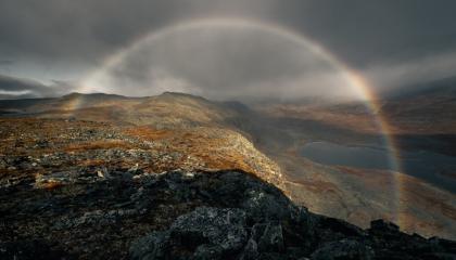 Tunturimaisema, jonka ylle valoilmiö muodostaa kaarevan muodon.