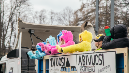 Lukion päättävät abiturientit heiluttavat värikkäissä asuissaan penkkari-kuorma-auton lavalta.