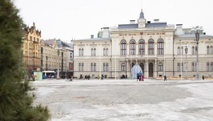 Talvinen, luminen näkymä Tampereen Keskustorilta kohti Raatihuonetta, joka on kuvan taustalla ja esiin nousee rakennuksen edustan torialue.