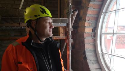 Opiskelija työvaatteissa rakennustyömaalla.