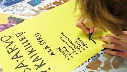 Nuori on tekemässä mielenosoitusjulistetta, jossa puhutaan tasa-arvosta.