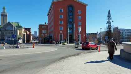 Auto ja kävelijä Lapintien kiertoliittymässä, hotelli Tammer ja paloasema taustalla.