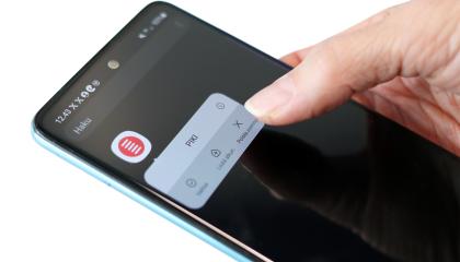 Käsi pitämässä puhelinta, jonka näytöllä PIKI-sovellus. 