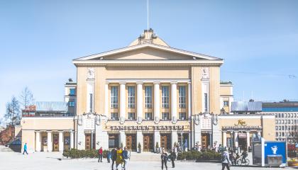 Tampereen teatterin julkisivu Keskustorilta kuvattuna. Ihmisiä kävelemässä.