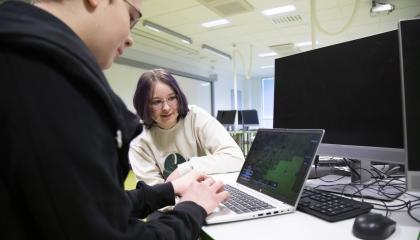 Kaksi nuorta kannettavan tietokoneen äärellä.