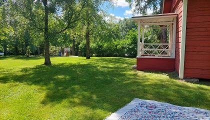 Red cottage and blanket on the lawn.