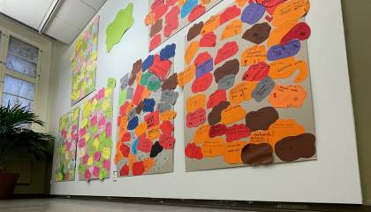 Valkoisella seinällä kuusi isoa teosta, joissa lasten kirjoittamia viestejä eri värisille lapuille.