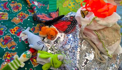 Lorupiiritarvikkeita, kuten pehmoleluja ja kankaita, viltillä.